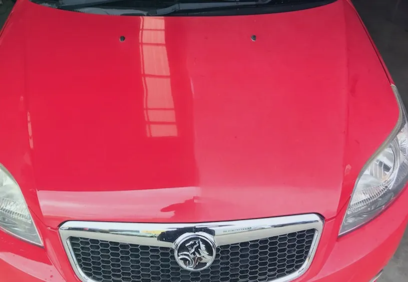 Red car bonnet after ceramic coating, showing a sharp reflection and deep gloss