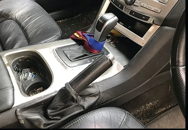 Grubby automatic gear selector surround with debris in the cup holders