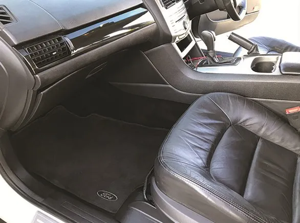 The same footwell cleaned, carpet dark and even, sill polished