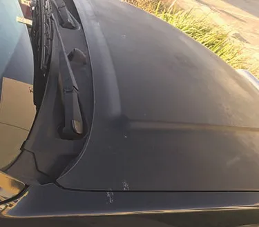 Dark ute bonnet with paint gone flat and chalky from sun exposure