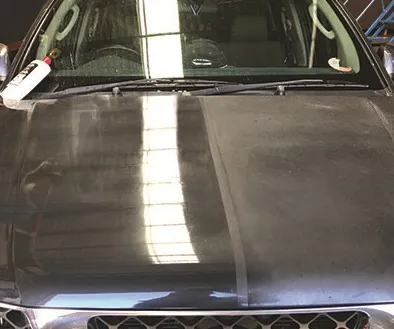 A ute bonnet mid-correction, one polished strip contrasting against the dull paint