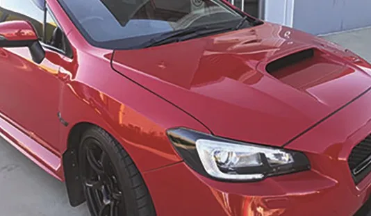 Red Subaru WRX finished with a cut and polish and ceramic coating, front three-quarter view