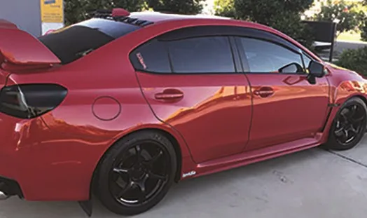 Red Subaru WRX rear three-quarter view with a deep gloss finish